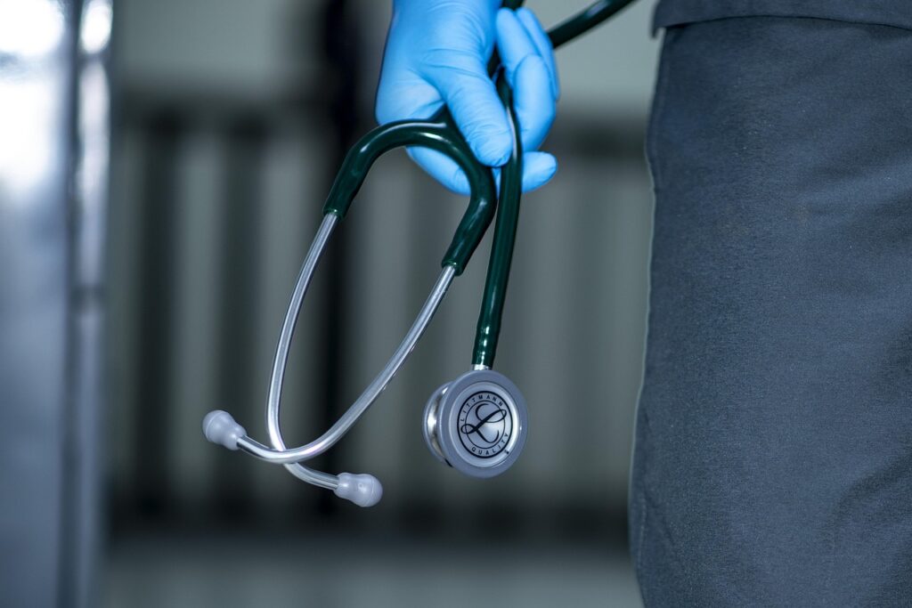 doctor holding stethoscope - Primary Care Doctors Near Me Accepting New Patients Without Insurance