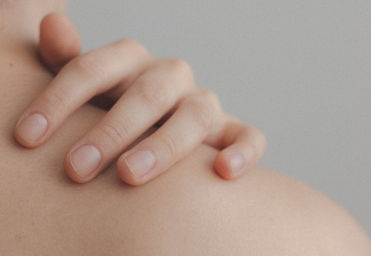 person touching shoulder - Actinic Keratosis Treatment