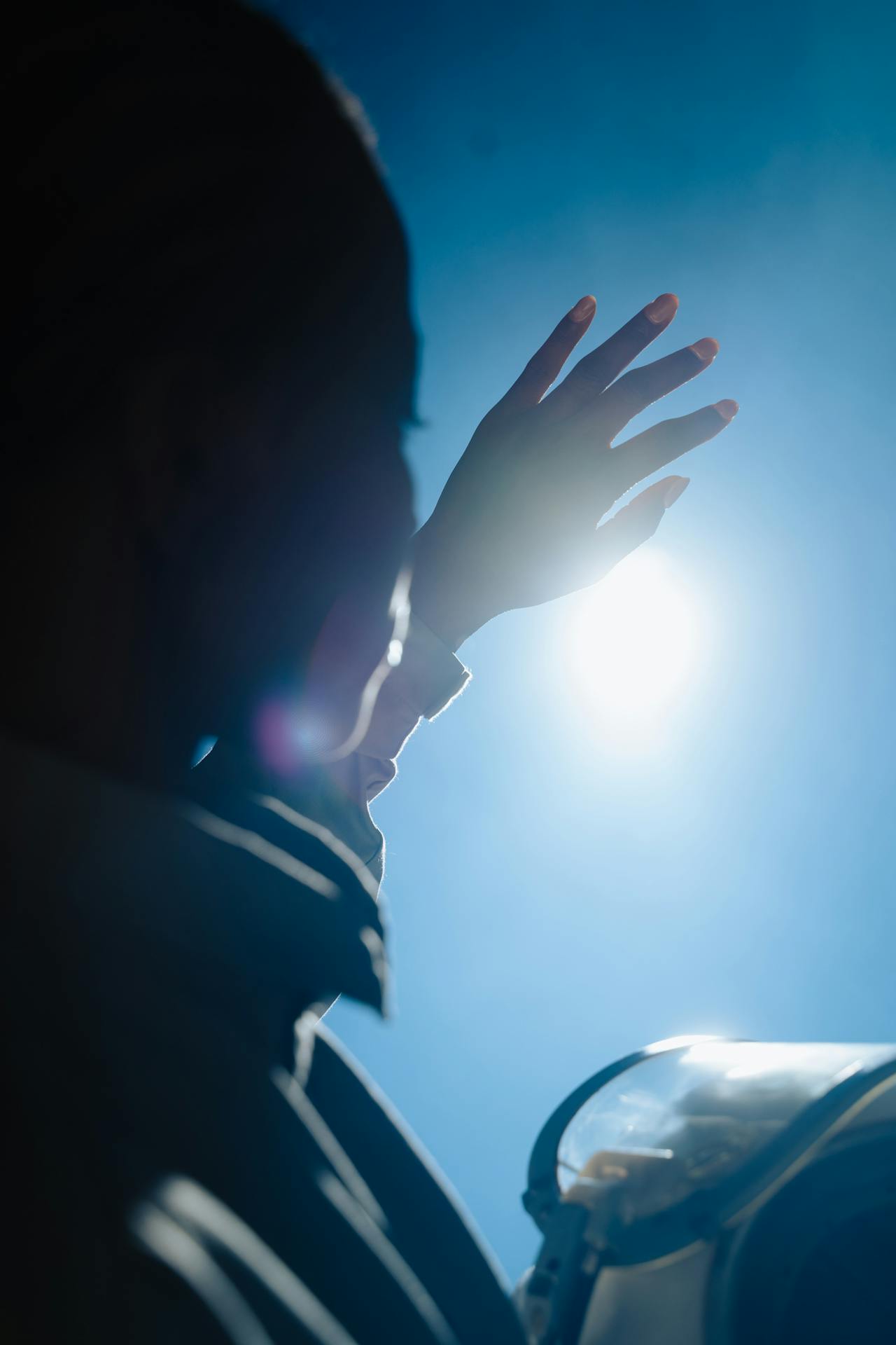 person trying to block sun with hand - Actinic Keratosis Treatment