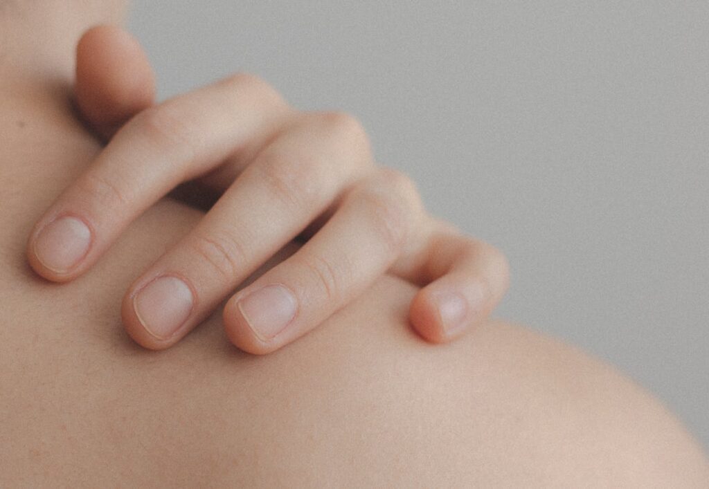 woman touching shoulder - Hyfrecator for Raised Skin Lesions