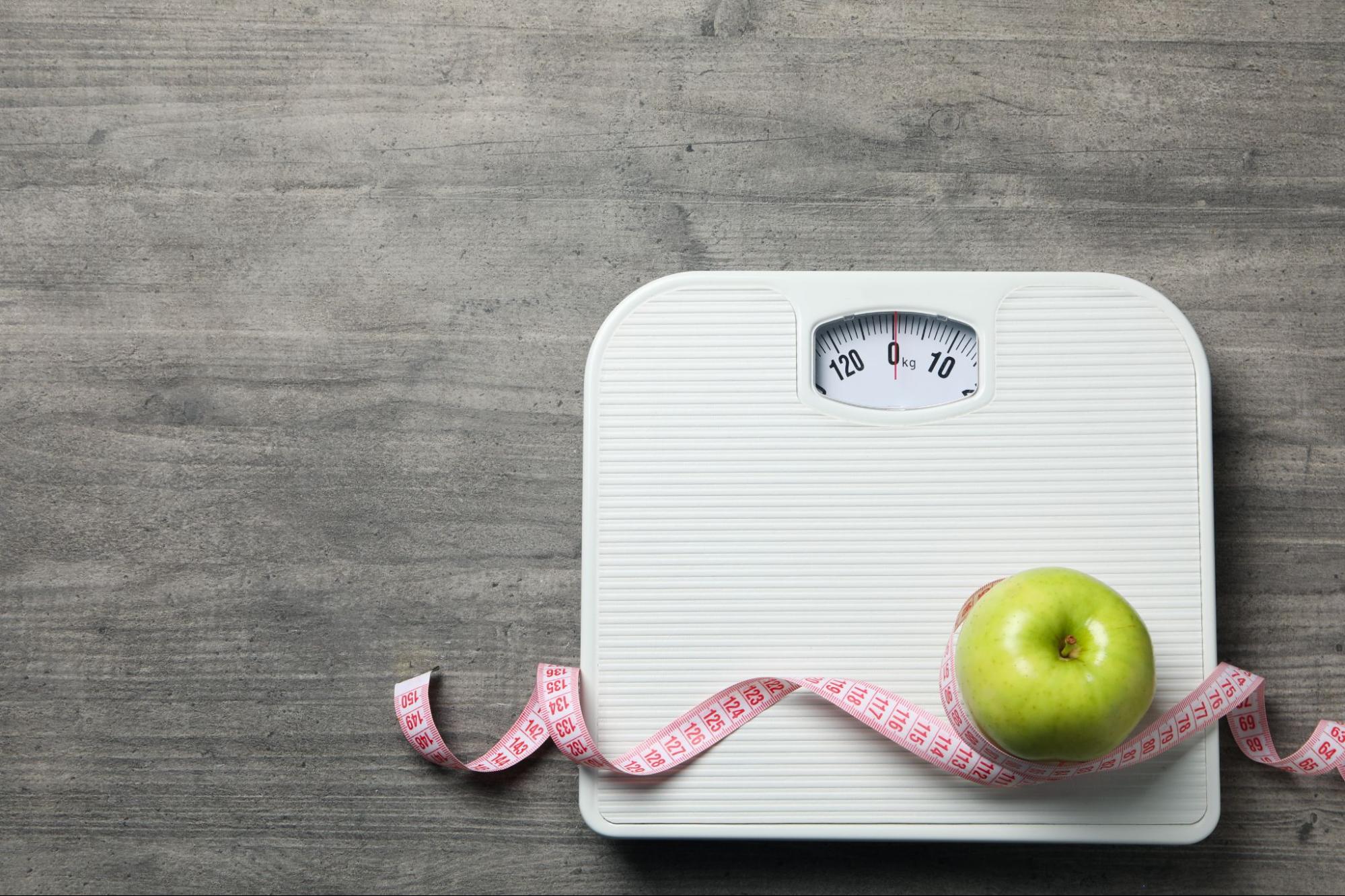 weighing scale, measuring tape, and apple