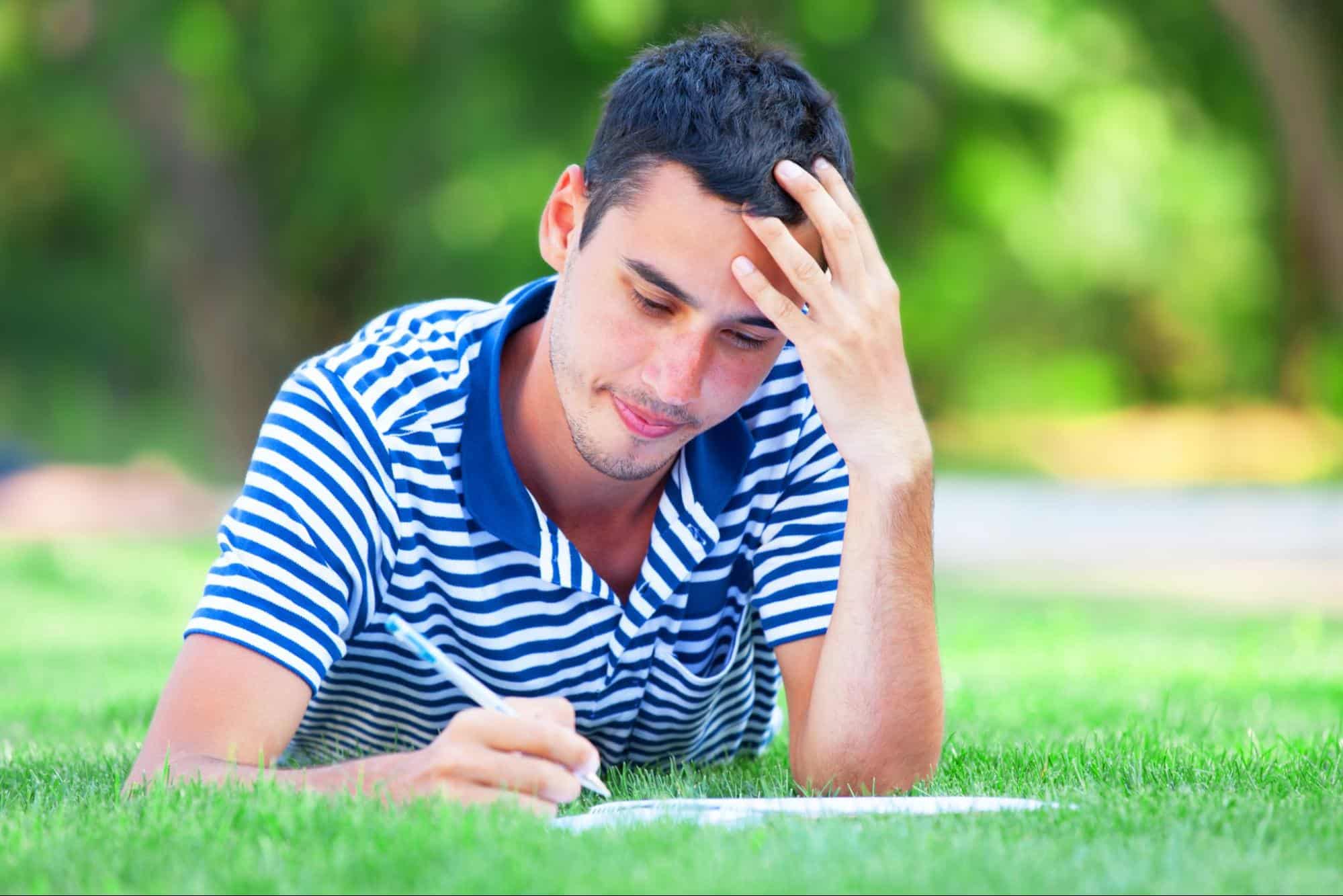 man writing while outdoors