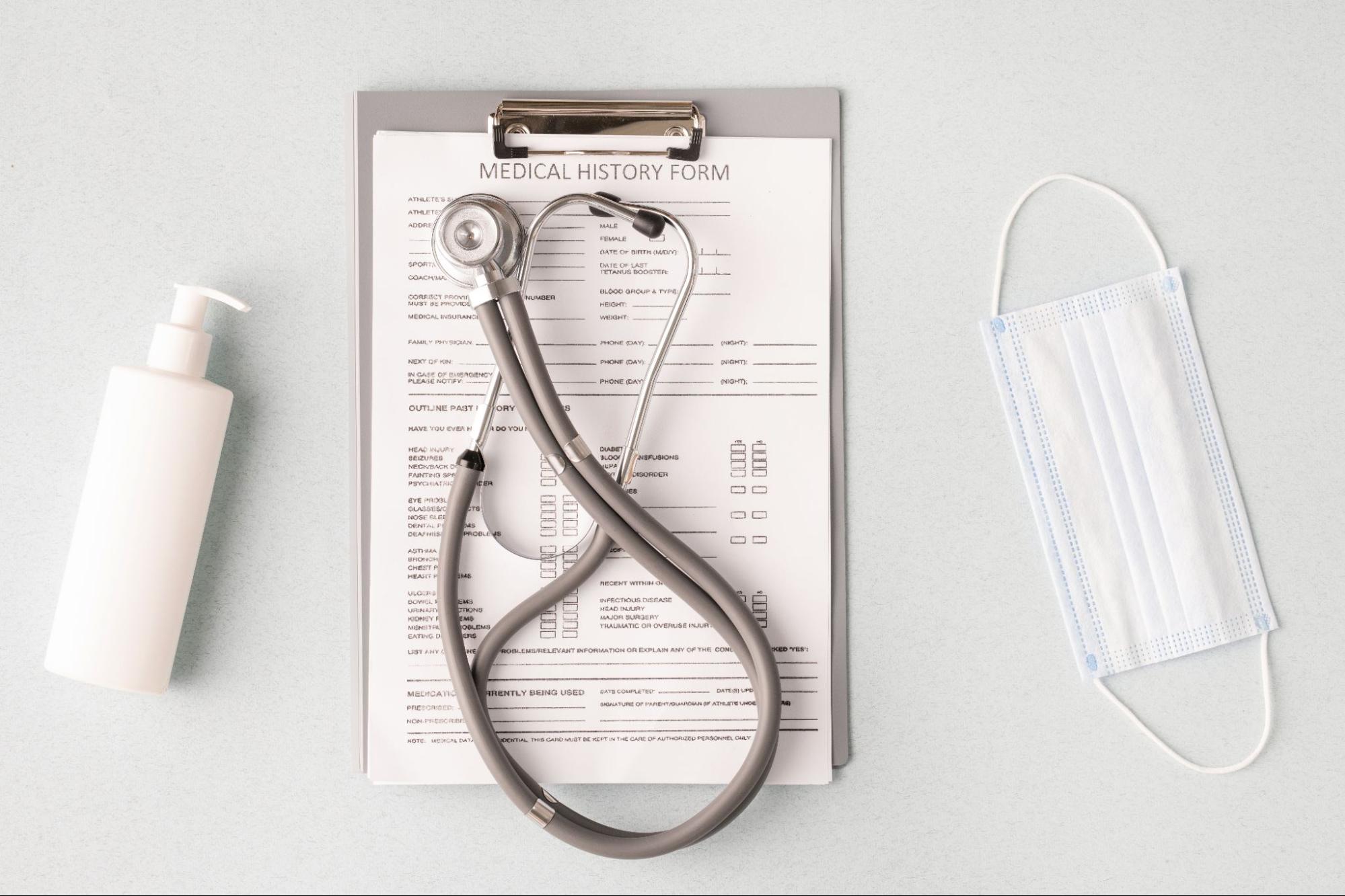 relationship-based primary care concept with stethoscope on medical history form and sanitizer