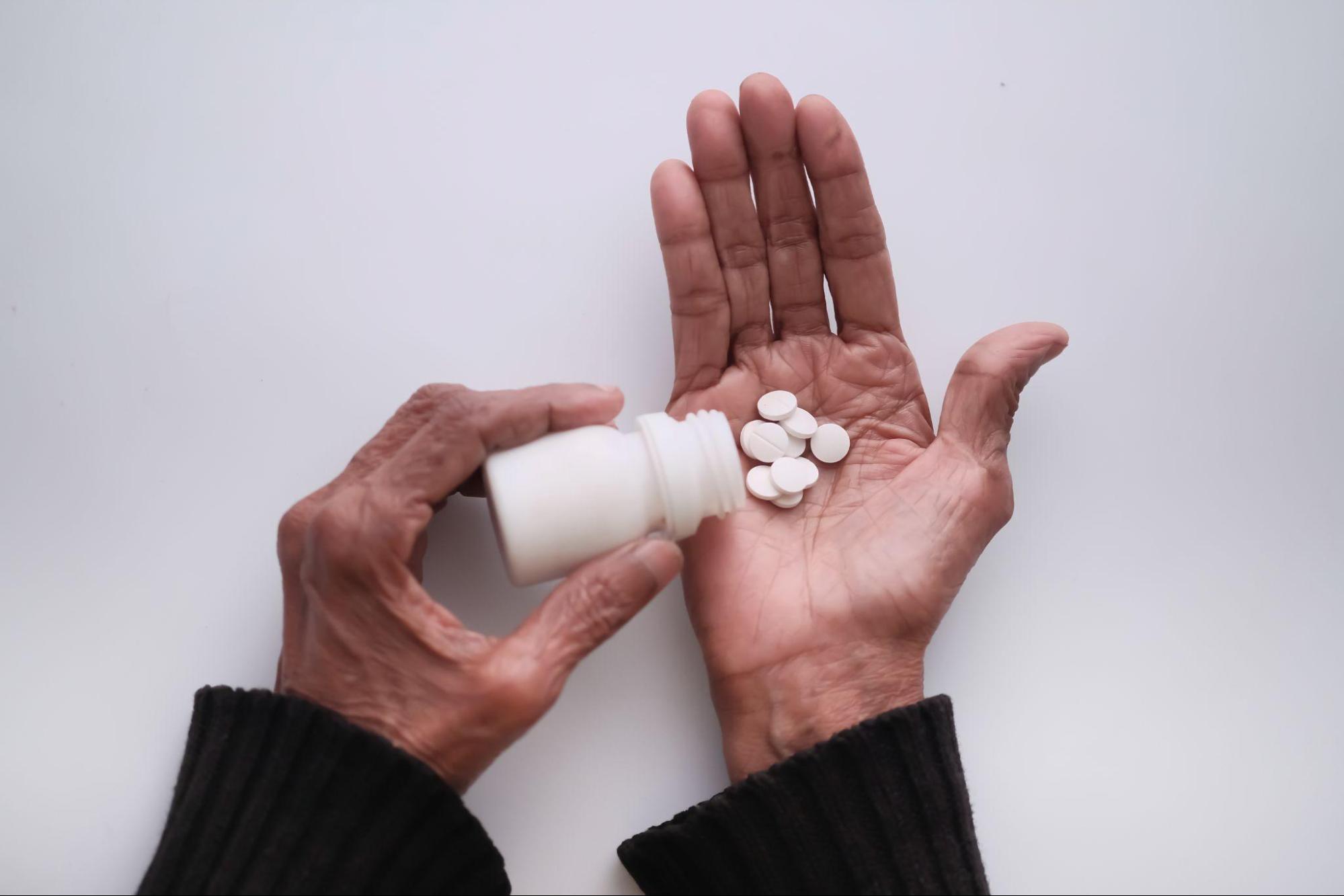 Older adult holding medication, representing the need for personalized medical guidance during scabies treatment for family members.