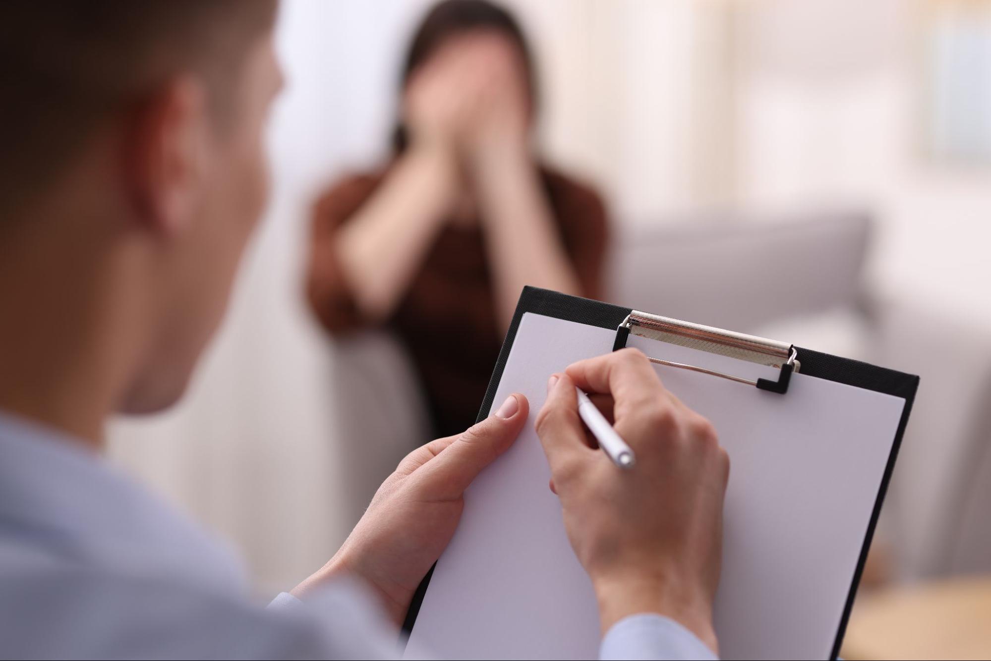 Healthcare professional discussing mental health progress and treatment goals with an adult patient.