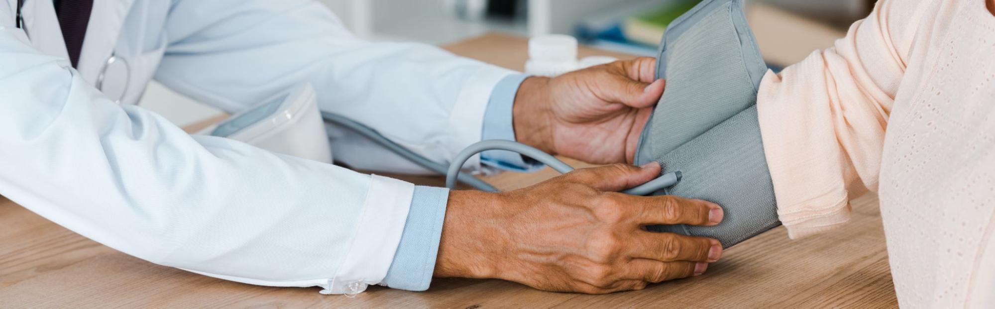 Doctor checking a patient's blood pressure during a cardiovascular health screening.