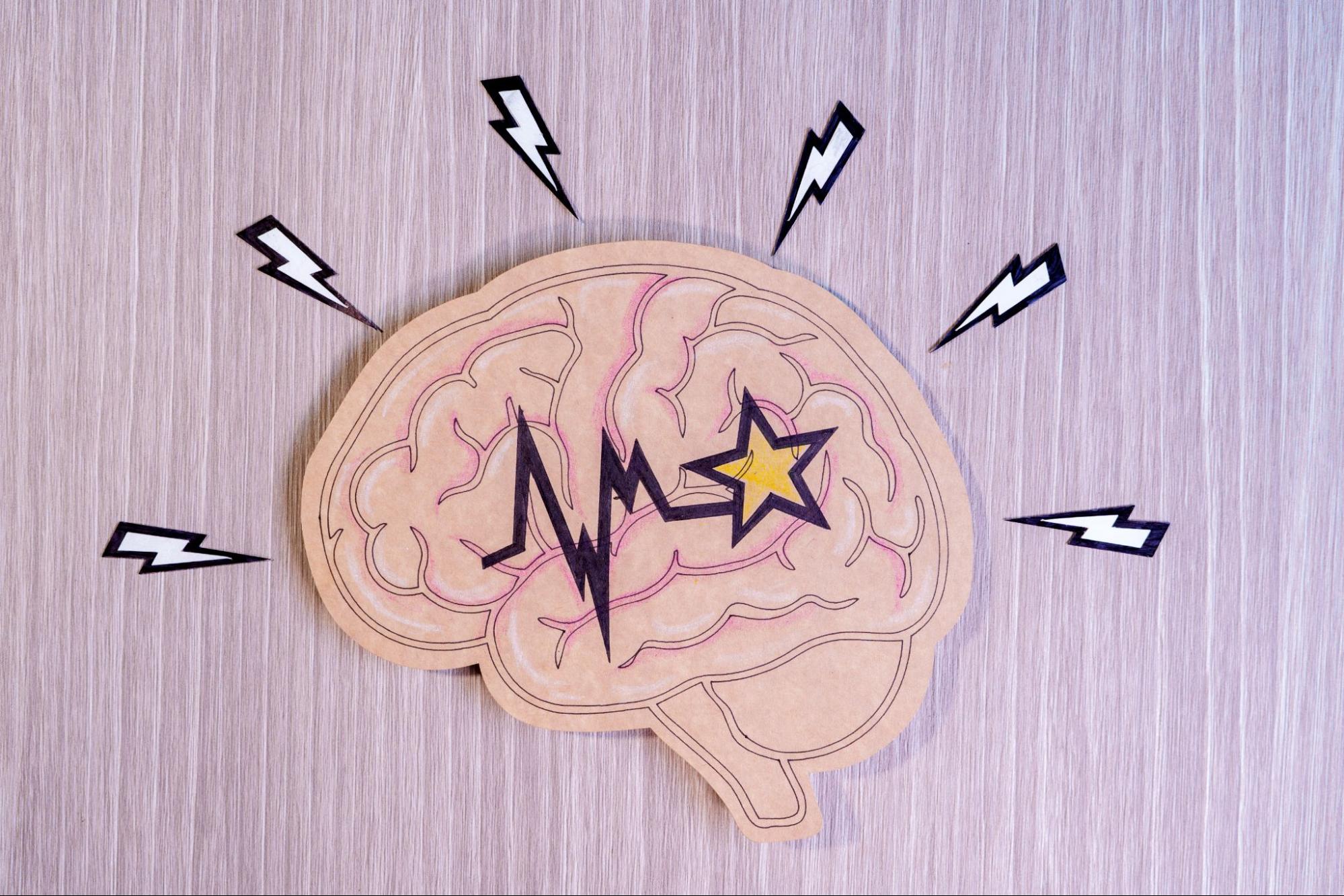 Illustrated brain with pulse lines and lightning symbols representing brain activity and ketamine’s effects on neural signaling.