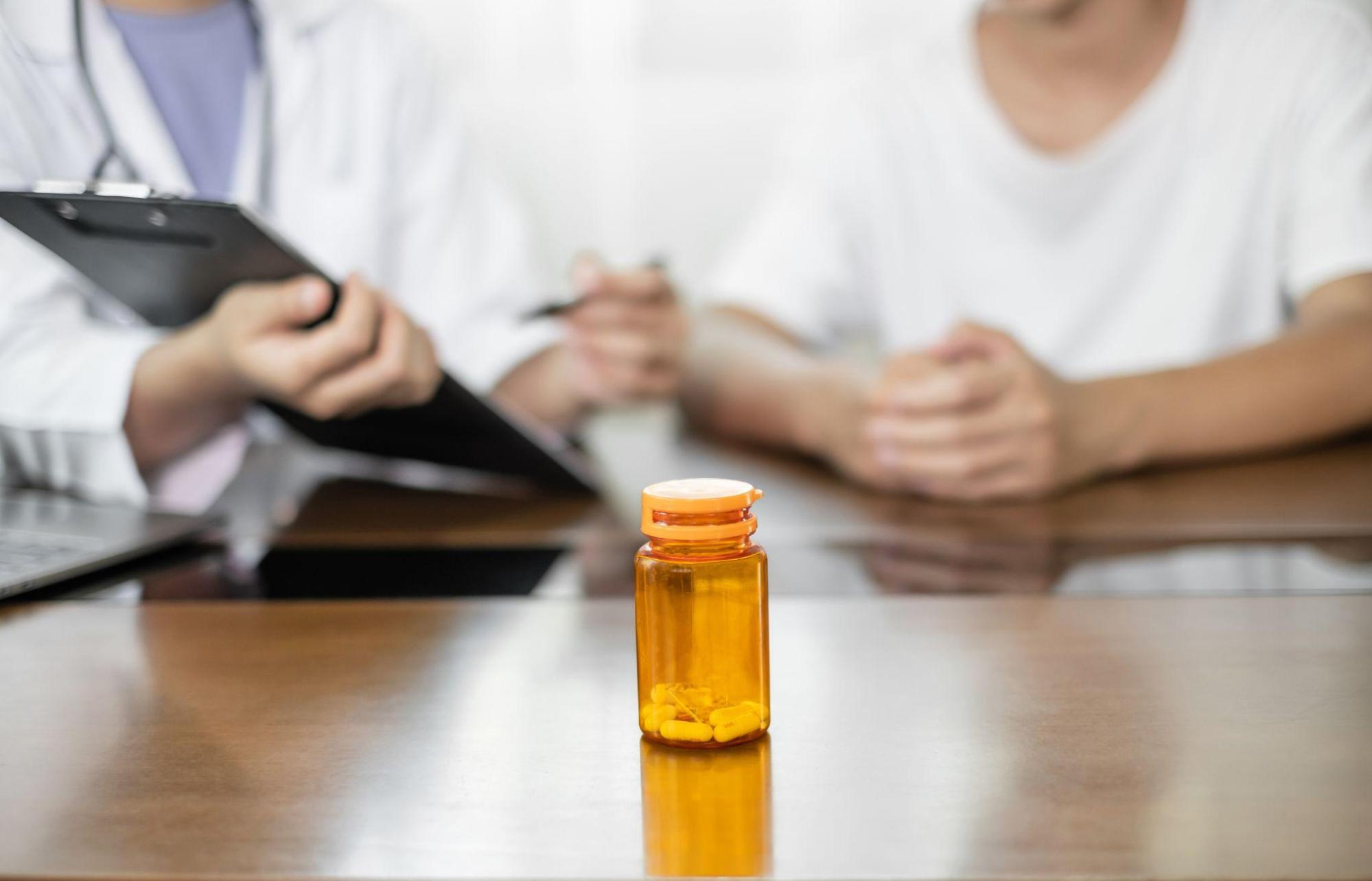 Doctor speaking with a patient about medication, treatment options, and supervised care.